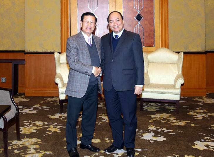 Deputy Prime Minister Nguyen Xuan Phuc meets Laos counterpart  - ảnh 1